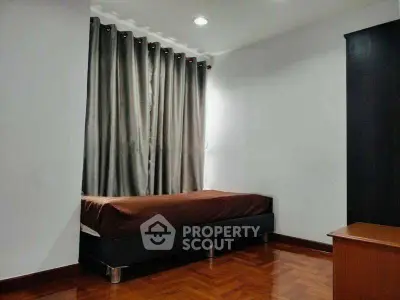 Cozy bedroom with wooden flooring and elegant curtains, perfect for restful nights.