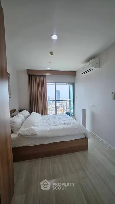 Modern bedroom with city view, featuring a cozy bed and air conditioning, perfect for urban living.