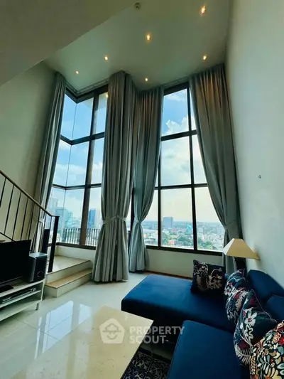 Luxurious high-ceiling living room with panoramic city views and elegant decor.