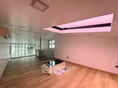 Spacious modern living room with skylight and wooden flooring