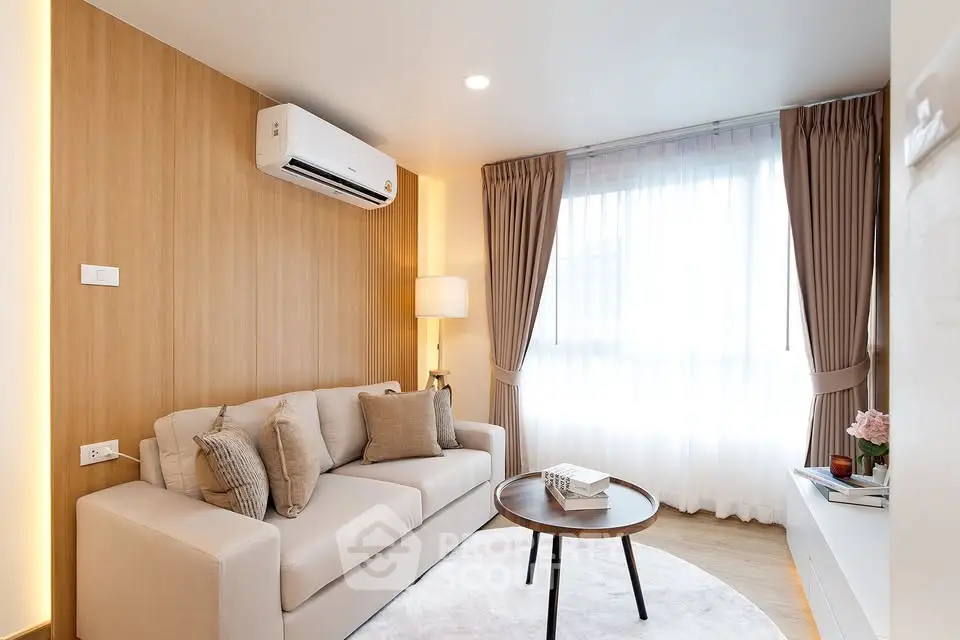 Modern living room with cozy sofa, air conditioning, and natural light
