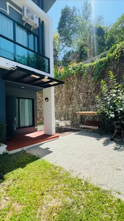 Charming outdoor patio with lush greenery and modern exterior design, perfect for relaxation and entertaining.