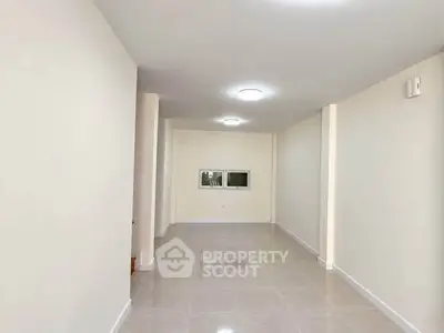 Spacious empty room with bright lighting and tiled flooring, ideal for customization.