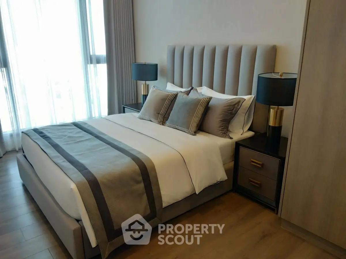 Luxurious bedroom with elegant decor and natural light, featuring a plush bed and stylish bedside lamps.
