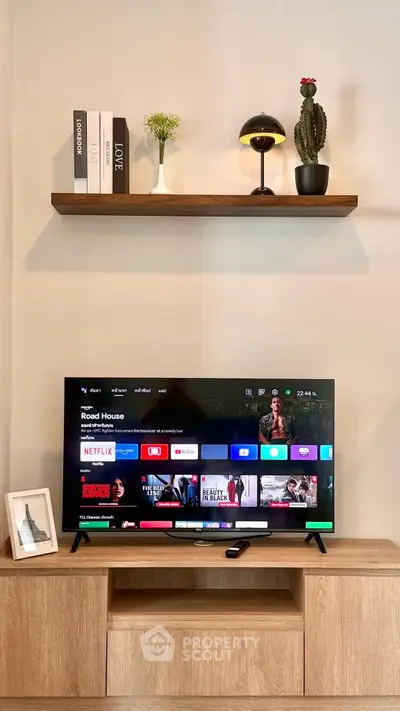 Modern living room with stylish TV setup and wooden shelf decor