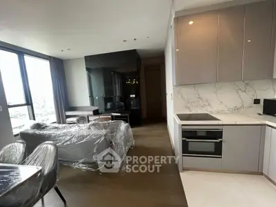 Modern open-layout living room and kitchen with sleek design and natural light.