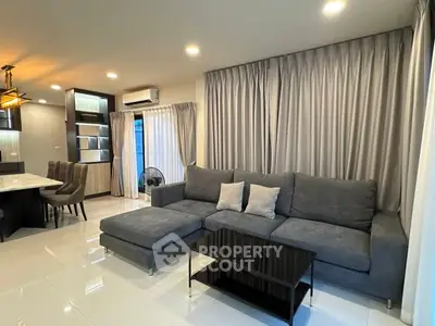 Modern living room with elegant gray sofa and open kitchen layout