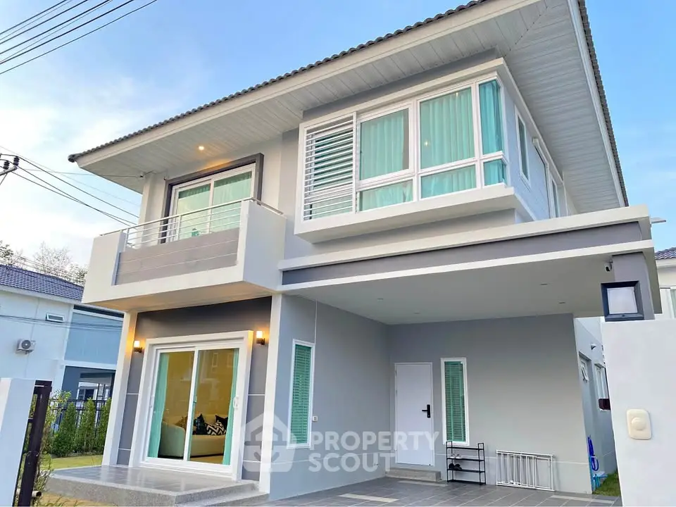 Modern two-story house with sleek design and large windows, featuring a spacious balcony and contemporary architecture.