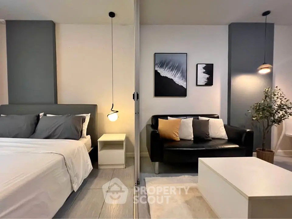 Modern studio apartment with stylish decor, featuring a cozy bed and chic living area.