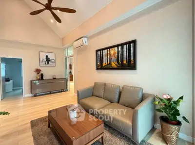 Elegant living room with modern decor and high ceiling, featuring a cozy sofa and stylish artwork.