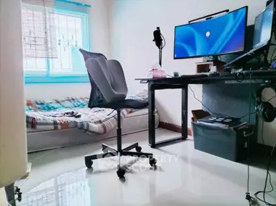 Modern home office setup with ergonomic chair and dual monitors in a bright room.