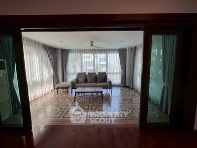 Spacious living room with elegant tile flooring and large windows for natural light.