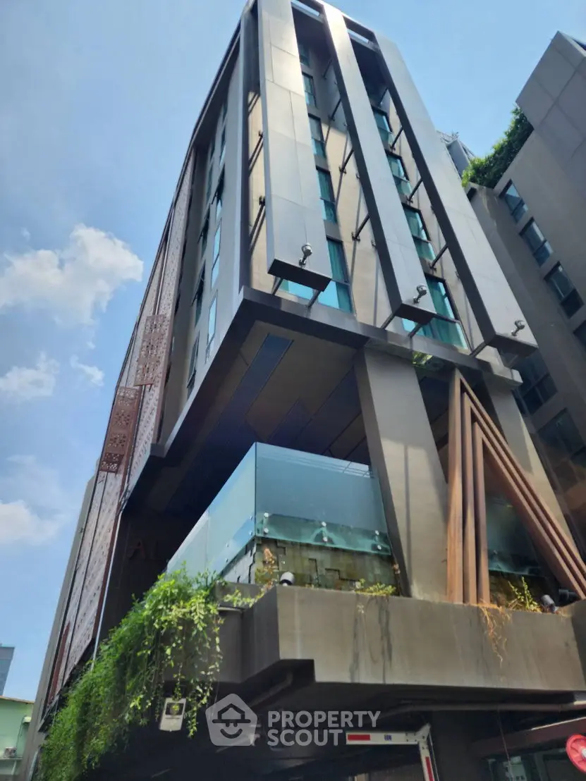 Modern architectural building with sleek design and glass balconies in urban setting.