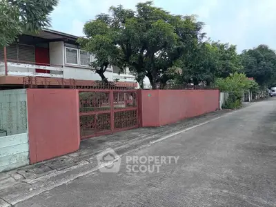 Charming residential property with gated entrance and lush greenery