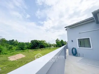 Modern home exterior with spacious balcony and lush green view