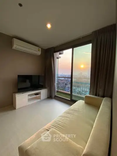 Modern living room with stunning sunset view from large window and cozy sofa.