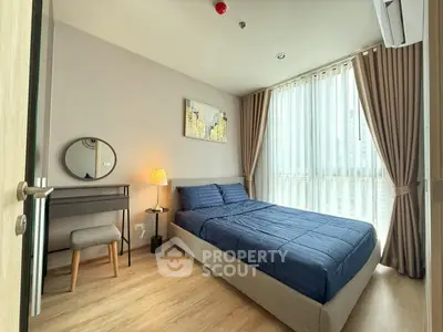 Modern bedroom with cozy decor and large window for natural light.