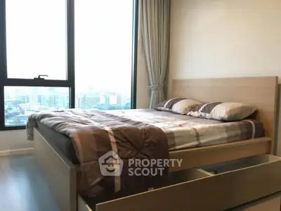 Modern bedroom with large window and city view, featuring a stylish bed and elegant curtains.