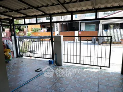 Spacious covered patio with tiled flooring and open gate view