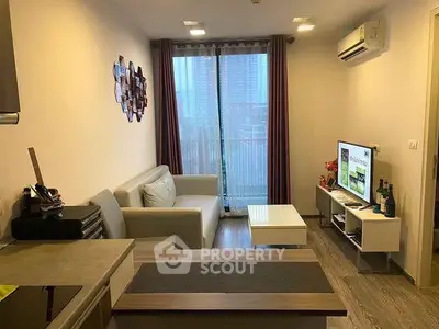 Modern living room with cozy sofa, wall-mounted TV, and air conditioning in a stylish apartment.