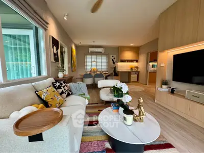 Spacious modern living room with stylish decor and open kitchen layout, perfect for entertaining.