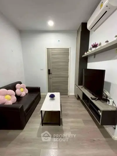 Cozy living room with modern decor, featuring a sleek TV unit and comfortable seating.