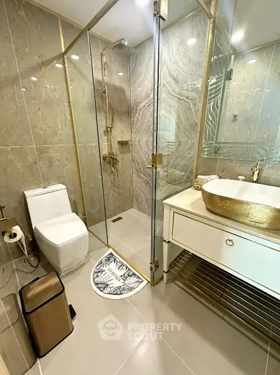 Luxurious modern bathroom with gold accents and glass shower enclosure
