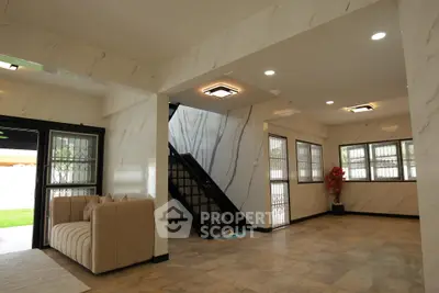 Spacious modern living room with elegant staircase and natural light