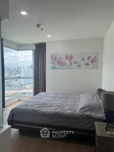 Modern bedroom with city view and stylish decor in high-rise apartment.