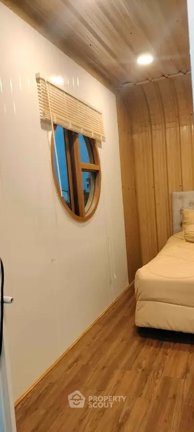 Cozy bedroom with unique circular window and wooden accents