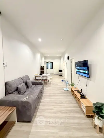 Modern living room with sleek furniture and wall-mounted TV, perfect for relaxation.
