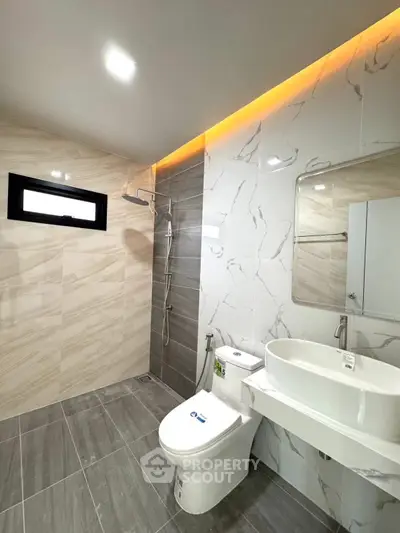 Modern bathroom with sleek design, featuring a walk-in shower and elegant fixtures.