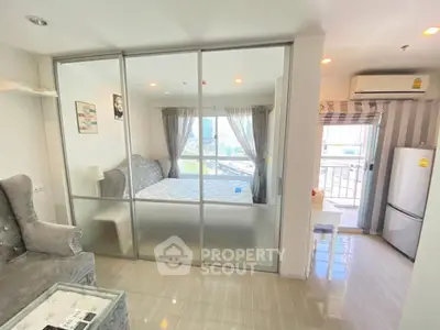 Modern apartment with glass partition, cozy living area, and bright kitchen with city view.