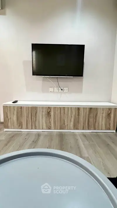 Modern living room with sleek TV setup and stylish wooden cabinet.