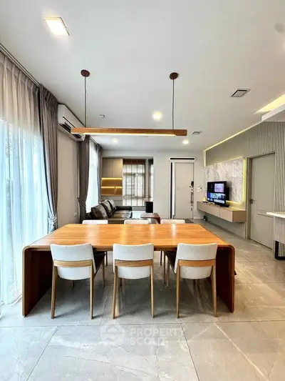 Modern living room with elegant dining area and stylish decor, featuring large windows and contemporary furniture.