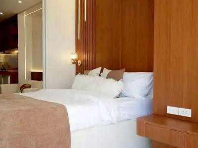 Luxurious bedroom with modern wooden accents and plush bedding in a stylish apartment.