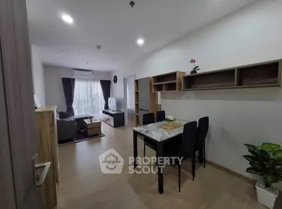 Modern living room with dining area, stylish furniture, and natural light from large windows.