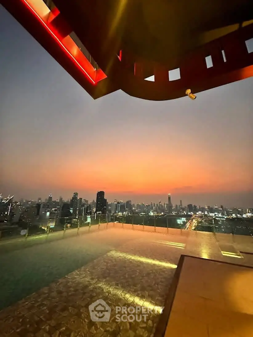 Stunning rooftop view of city skyline at sunset with poolside ambiance.