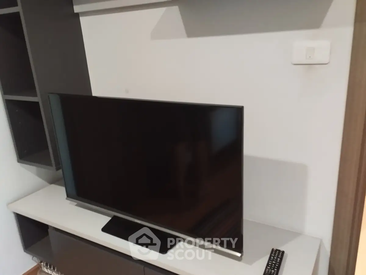Modern living room with sleek TV setup and stylish shelving unit.