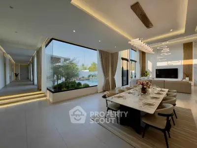 Luxurious open-plan living and dining area with modern decor and large windows offering garden views.