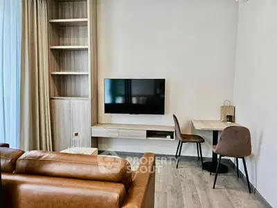 Modern living room with sleek TV setup and cozy seating area in stylish apartment.