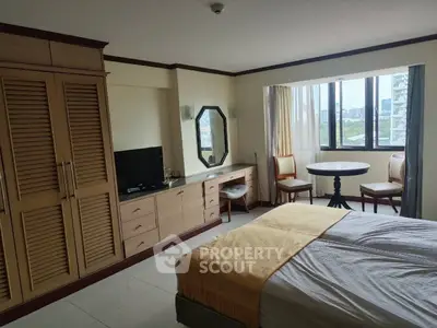 Spacious bedroom with large windows and elegant furnishings, offering a cozy and inviting atmosphere.