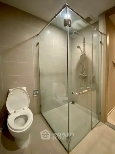 Modern bathroom with glass shower enclosure and sleek toilet design.