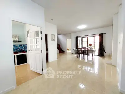 Spacious open-plan living and dining area with modern kitchen and natural light.