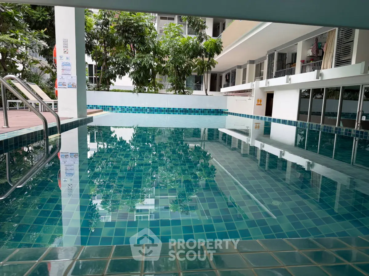 Luxurious residential pool area with modern design and lush greenery, perfect for relaxation and leisure.
