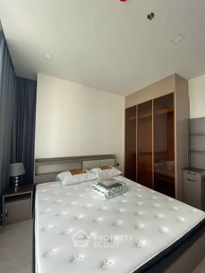 Spacious bedroom with modern design and ample natural light, featuring a large bed and stylish wardrobe.