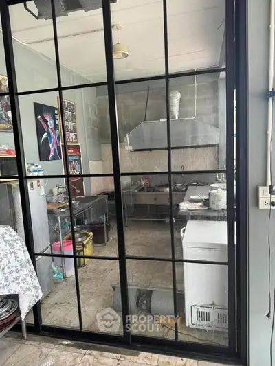 Industrial-style kitchen with glass partition and stainless steel appliances