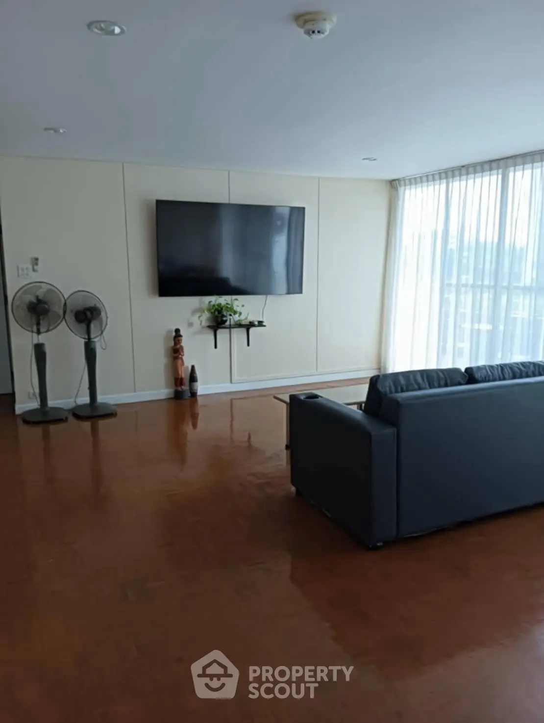 Spacious living room with modern decor and large window for natural light.