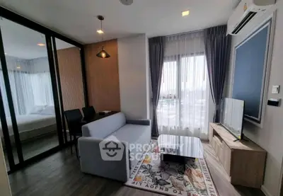 Modern living room with stylish decor and large window offering natural light.