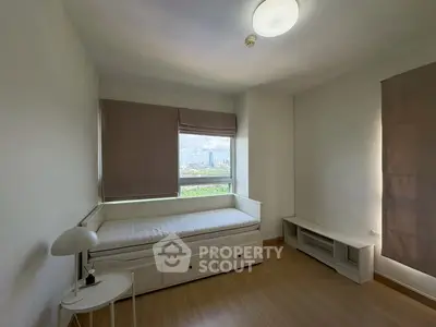 Bright bedroom with city view, featuring a single bed and minimalist decor.